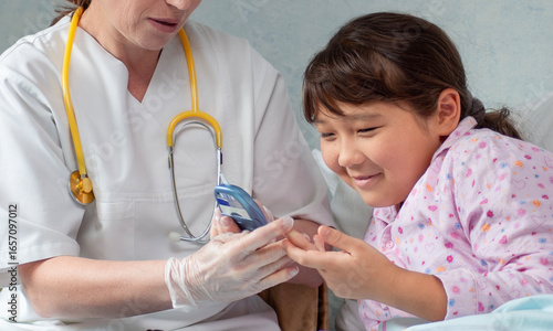 Asian girl at hospital getting her blood sugar measured by doctor or nurse during medical health check-up to prevent diabetes