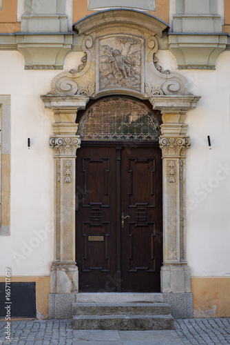 Wallpaper Mural Artistic carved wooden door with ornate stone arch and detailed bas-relief, showcasing elegant craftsmanship of historical architecture. Art, culture, design inspiration and architectural heritage Torontodigital.ca