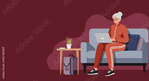 Senior woman in activewear using a laptop on a sofa at home. Represents remote work, online learning, modern lifestyle, and technology engagement for seniors.