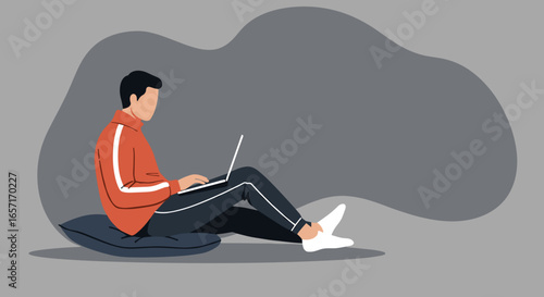 A person sits comfortably on a cushion, working on a laptop. Ideal for themes of remote work, online learning, relaxation, and modern lifestyle.