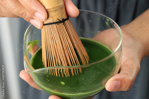 Asian Woman Hand Whiskin Mathca using Chasen on Clear Bowl