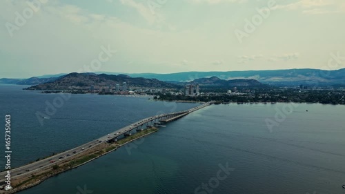 Wallpaper Mural High Aerial over Okanagan Lake entire view William R Bennett Bridge Central Okanagan BC calm blue water traffic cars trucks commuting mountainous background light blue sky wispy clouds Torontodigital.ca