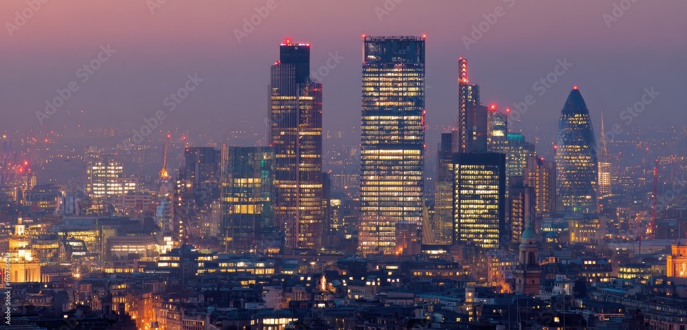 Obraz premium City skyline at twilight, illuminated skyscrapers