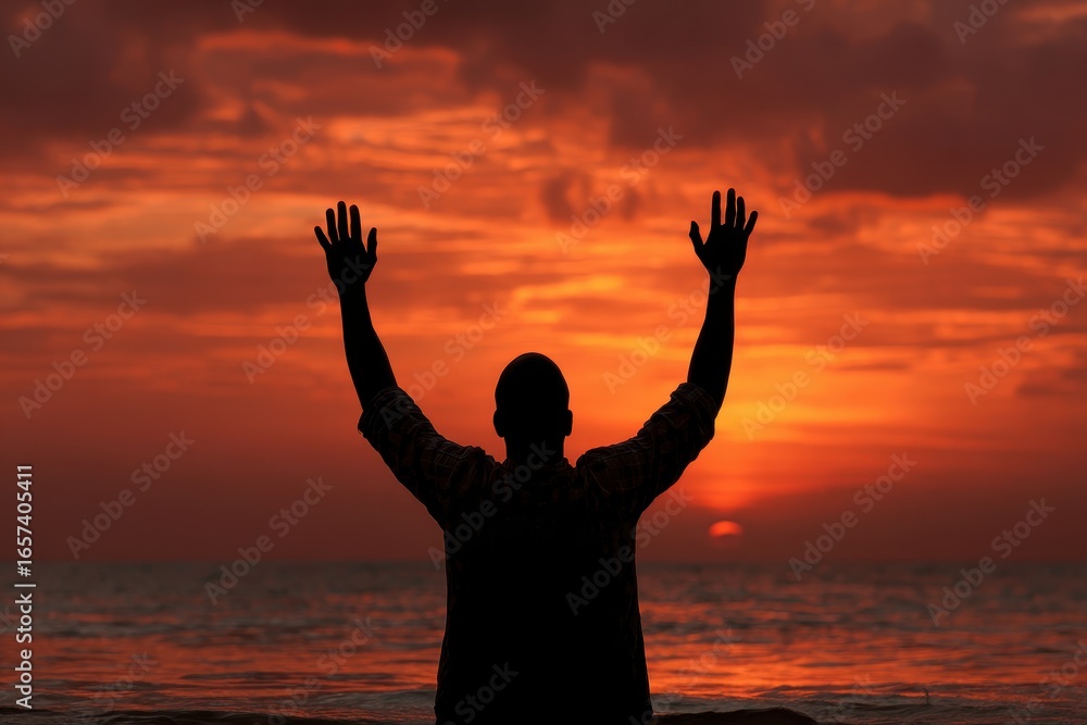 Fototapeta premium Man Surrendering: Silhouette of Man with Raised Hands at Beach Sunset