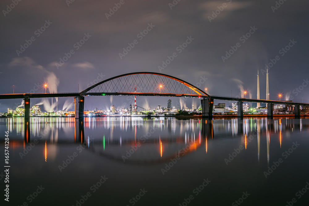 Obraz premium Night View of Illuminated Industrial Bridge and Factory Reflections ライトアップされた橋と工場の夜景が水面に美しく映る風景