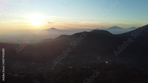 Sikunir Golden Sunrise, Indonesia, captured on August 19, 2025. Majestic golden light illuminating mountain peaks above a sea of clouds, with silhouettes of rolling hills and clear morning sky.