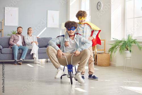 Bild auf Leinwand Happy playful family, parents and excited funny little brothers at home wearing