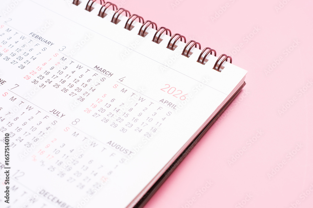 Fototapeta premium Paper calendar for 2026 on pink background close-up.