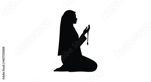 Woman kneeling in prayer with rosary in hand in silhouette