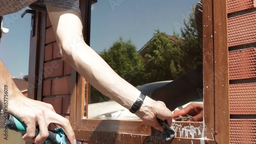 Man cleaning glass window with squeegee and foam