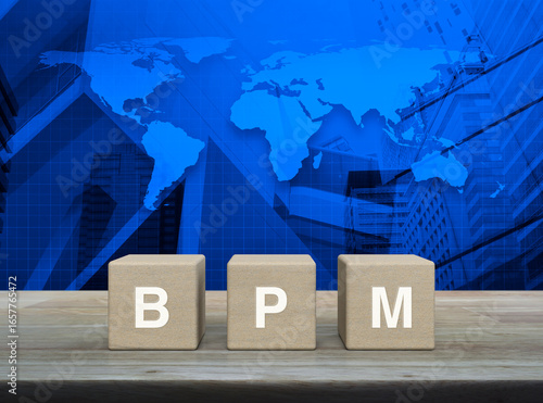 Fototapeta Naklejka Na Ścianę i Meble -  BPM acronym on wood block cubes on wooden table over world map, modern office city tower and skyscraper, Business process management concept, Elements of this image furnished by NASA