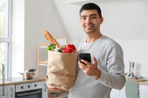 Young man with grocery bag ...