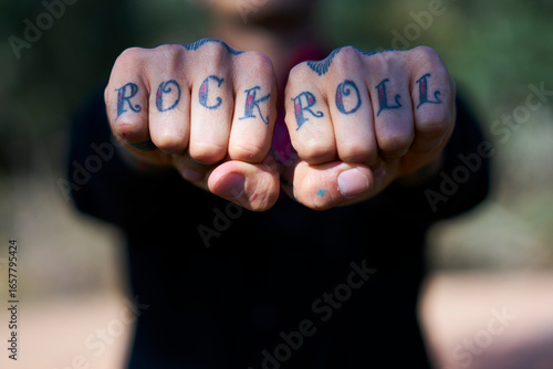 Fingers tattooed with 'Rock and Roll'
