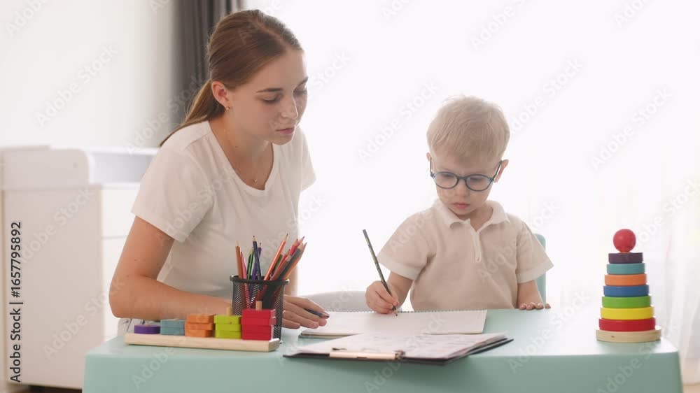 Having fun fun pencils. Speech therapist is with young boy indoors. Having fun fun pencils. Speech therapist is with young boy indoors.