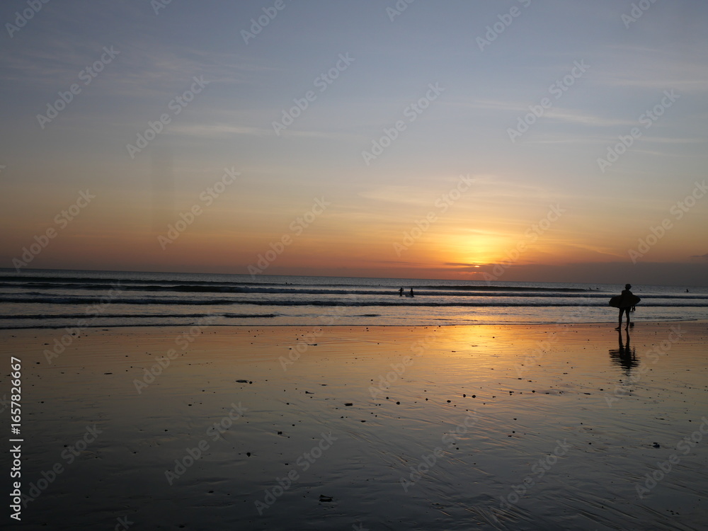 Fototapeta premium Bali’s sunset displays vibrant colors over the ocean, creating unforgettable, peaceful, and romantic moments daily.