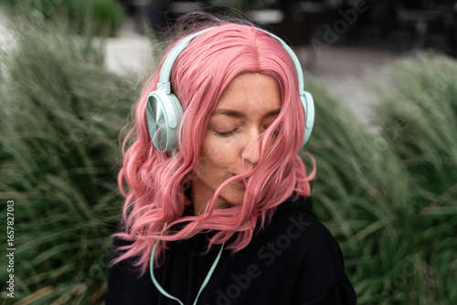 Young woman with eyes closed listening music through headphones