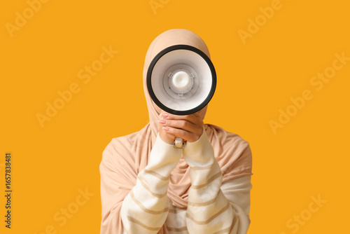 Tableau sur toile Muslim woman in hijab holding megaphone for public announcement and communicatio