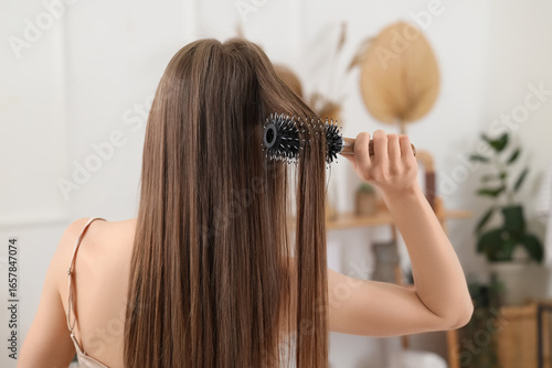 Young woman brushing her ha...