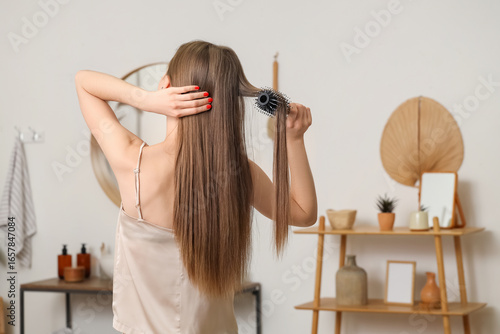 Young woman brushing her ha...