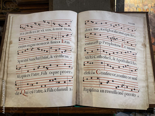 Open book displaying ancient Gregorian chants with musical notation, preserving sacred music traditions in Florence, Italy