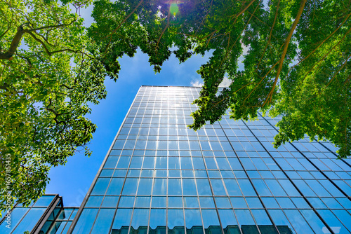 Modern business building in green sustainability eco-friendly environment under blue clean sky