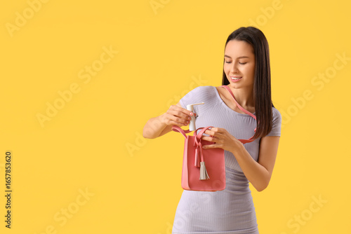Young woman putting spray f...