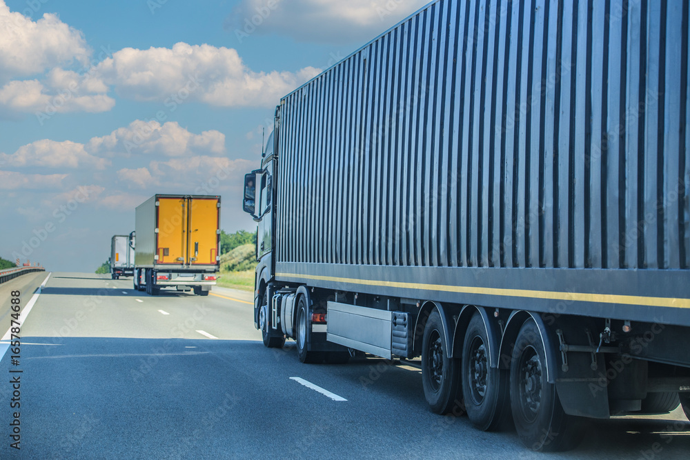 Convoy of large trucks moves along a country road Convoy of large trucks moves along a country road