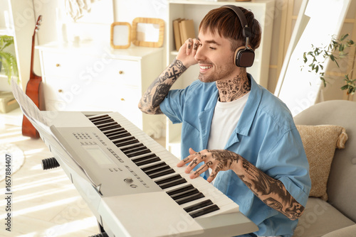 Young tattooed man in headp...