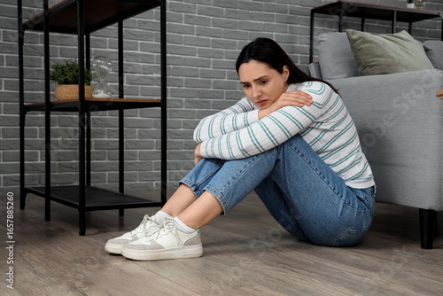Depressed young woman sitti...