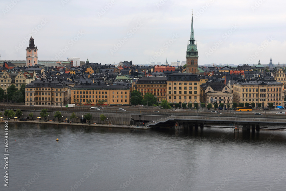 Obraz premium Photo with a view of St. Gertrude's Church (Tyska kyrkan), the historic buildings of the old town (Gamla Stan) and the waterfront against a cloudy sky in central Stockholm, Sweden