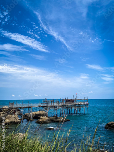 Wallpaper Mural Wooden fishing platform Trabocco standing on Adriatic coastline near Rocca San Giovanni, Chieti, Abruzzo, under bright blue sky Torontodigital.ca