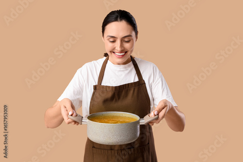 Young woman in apron holdin...