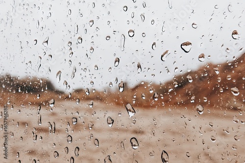 Raindrops on a car window, blurred desert landscape