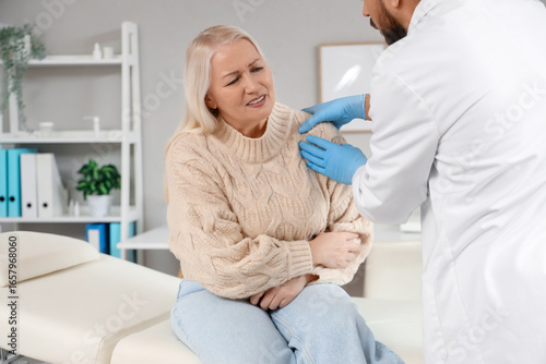 Male doctor examining matur...