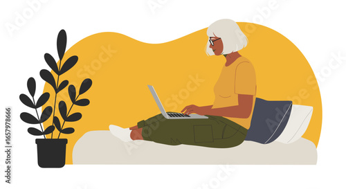Mature woman comfortably using a laptop at home, representing remote work, online learning, or leisure time.