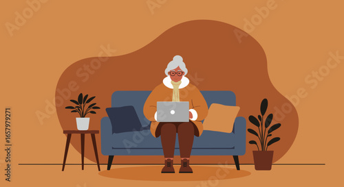 Senior woman comfortably using a laptop on a sofa at home, showcasing digital literacy and modern independent lifestyle.