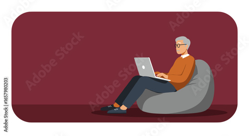 Senior man sitting comfortably on a beanbag chair, using a laptop. Ideal for remote work, online learning, retirement, or digital literacy concepts.