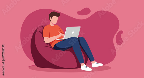 Young man comfortably working or studying on a laptop with a stylus while sitting on a bean bag chair. Ideal for remote work, online learning, or freelance concepts.