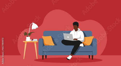 Young Black man comfortably working from home on his laptop in a modern living room setting. Ideal for remote work, education, and relaxed lifestyle concepts.