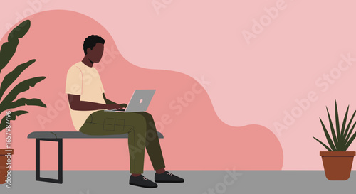 Young man focused on his laptop, working remotely in a modern, minimalist indoor setting with plants, showcasing flexible work and digital lifestyle.