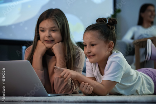 Cute sisters with laptop wa...