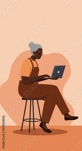 Mature Black woman using laptop on stool, embodying digital learning, remote work, and modern senior engagement.