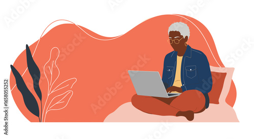 Elderly African American woman comfortably uses laptop at home, embracing technology for remote work, learning, or leisure. Modern senior lifestyle.