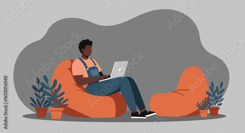 Man working comfortably on a laptop in a relaxed, modern home or office setting. Represents remote work, casual productivity, or flexible lifestyle.