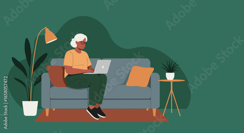 A senior woman comfortably uses a laptop on her sofa at home, representing modern remote work, online learning, and digital literacy for older generations.