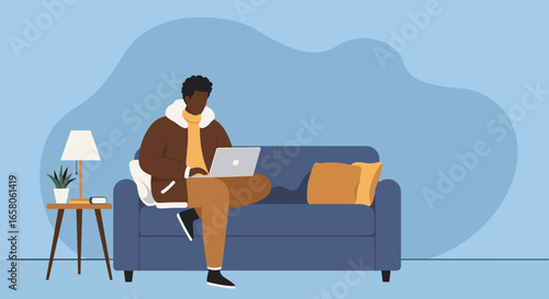 African American man working remotely on laptop from his comfortable home sofa. Ideal for themes of remote work, digital lifestyle, and relaxation.