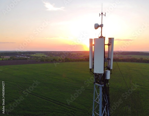 Wireless tower at sunset over fields