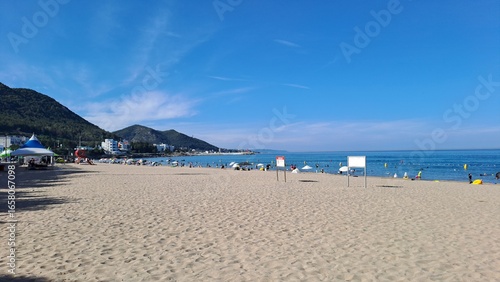 scenic korean beach with mountains and blue ocean under clear sky