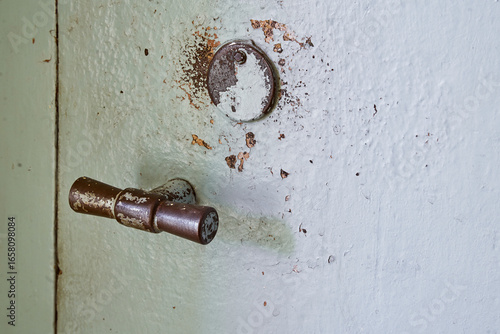 Close-up of a Rusty Door Handle and a Round Lock Plate


