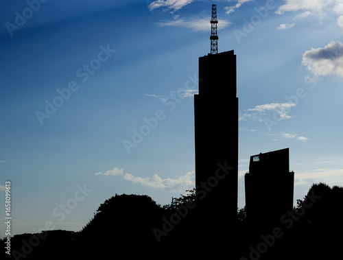 Silhouette of Two Skyscrapers and a Radio Tower against a Blue Sky